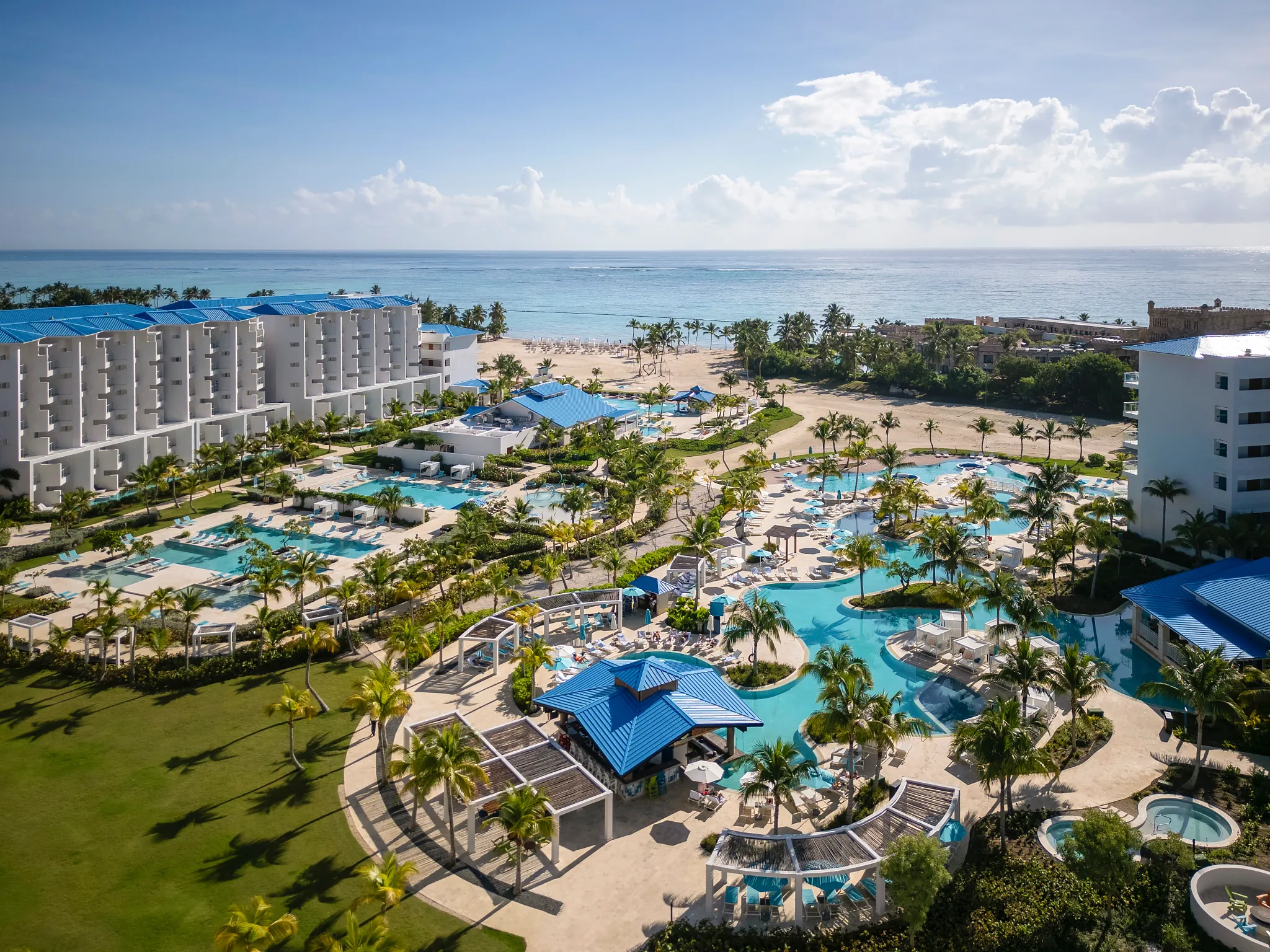 Elevated view of main pool area with ocean in the background at Dreams Cap Cana Resort & Spa.