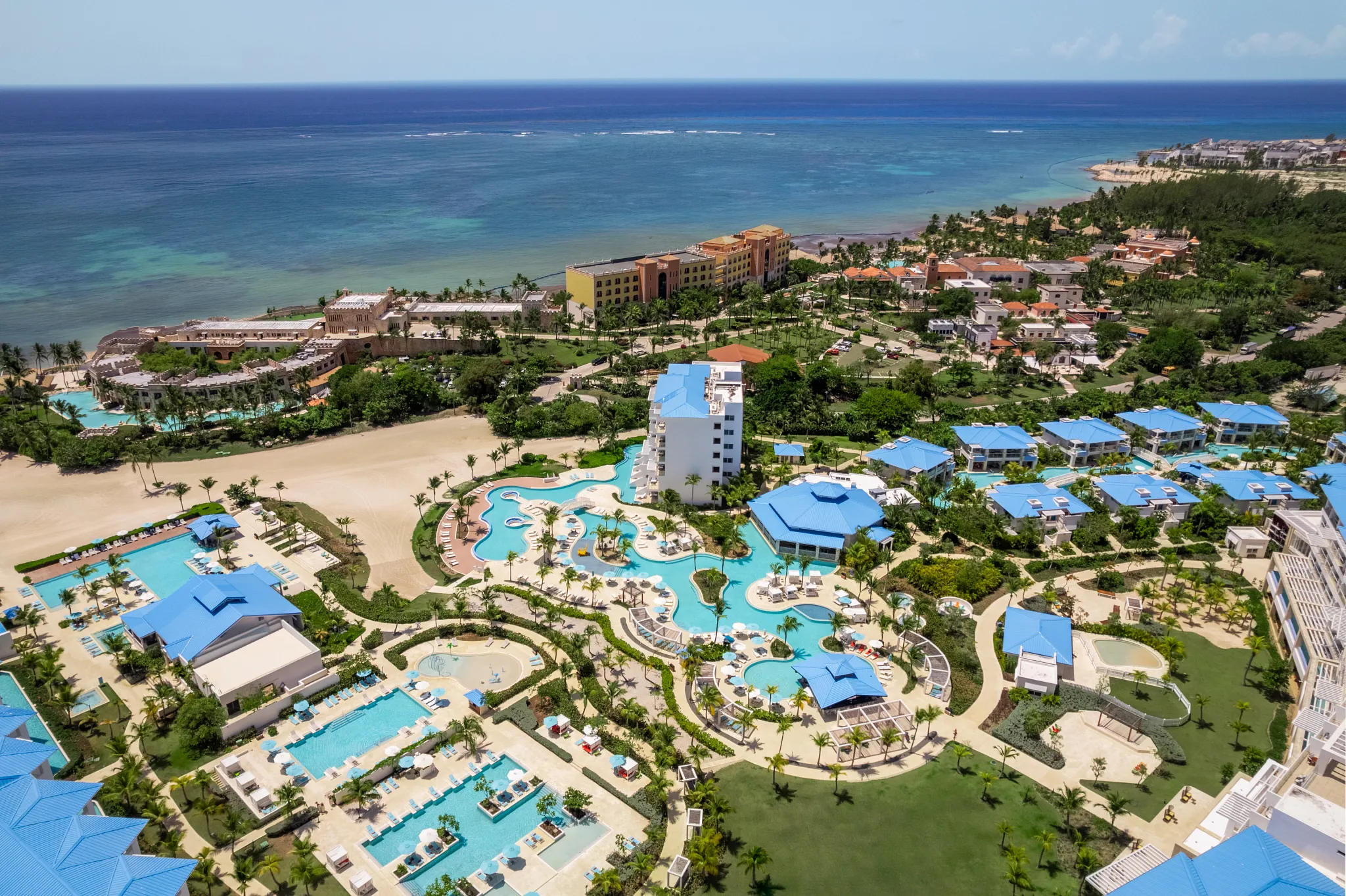 Aerial view of Dreams Cap Cana Resort & Spa with pools, gardens, and Caribbean coastline.