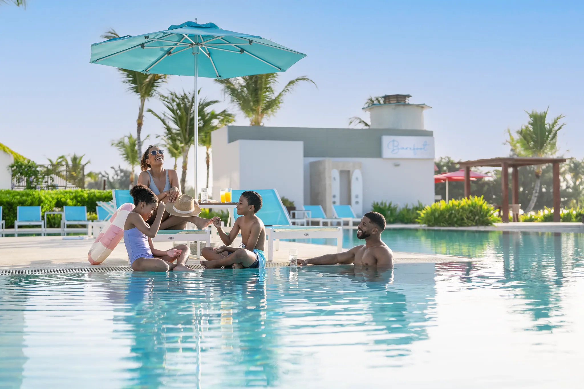 Family enjoying a relaxing day in a shallow pool at Dreams Cap Cana Resort & Spa, perfect for kid-friendly vacations in Punta Cana.