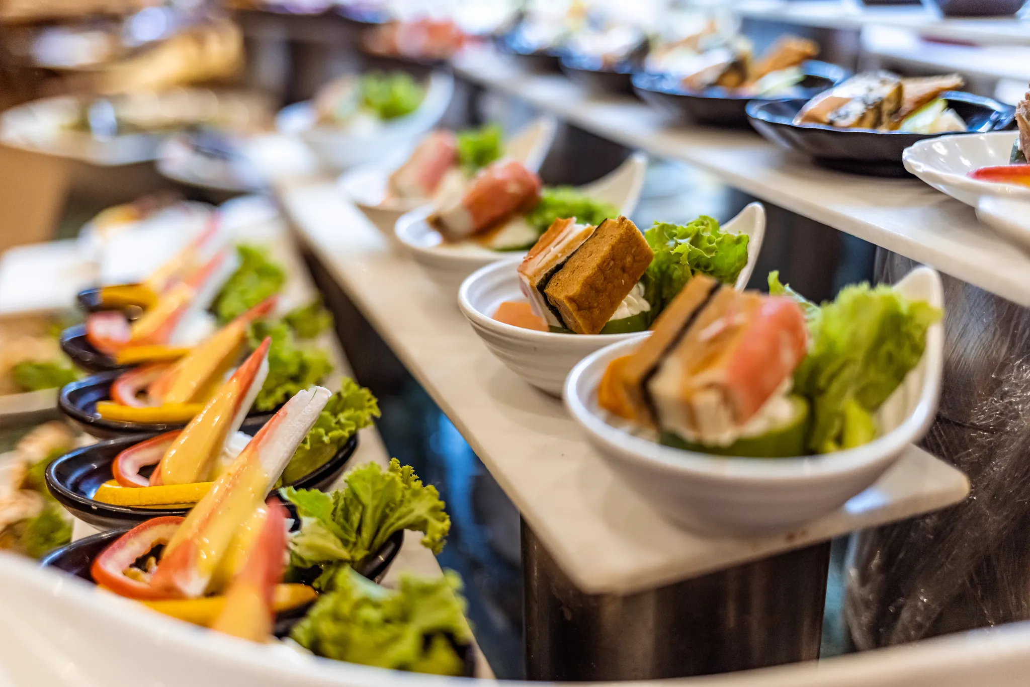 Mesa Central Kitchen restaurant at Dreams Cap Cana Resort & Spa featuring a contemporary buffet, open kitchen stations, and elegant casual dining atmosphere.